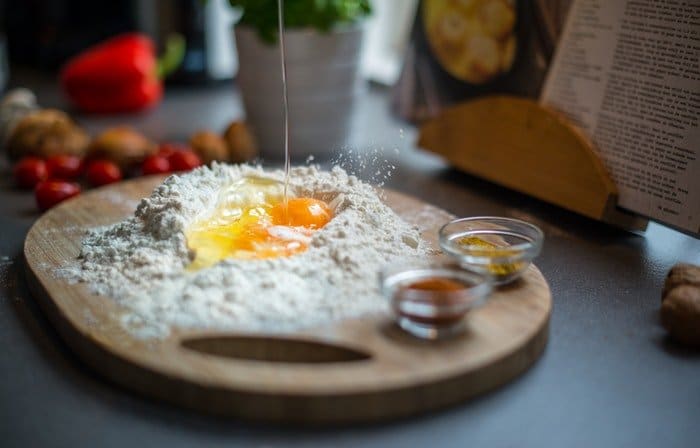 Huevos y harina en una tabla de cortar de madera