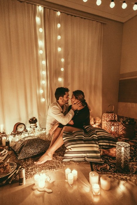 Una pareja abrazada en el piso de un dormitorio acogedor