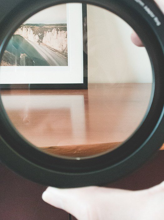 una mesa y un marco de fotos con reflejos en la madera vistos a través de un filtro de lente de cámara CPL