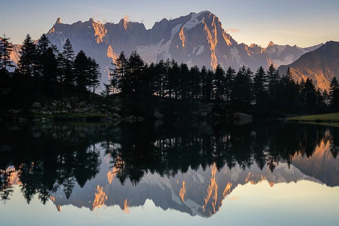 Un impresionante paisaje montañoso reflejado en un lago debajo