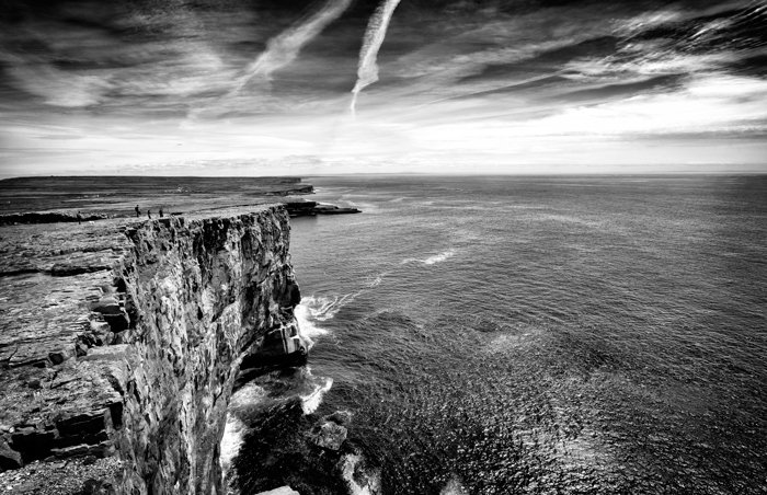 Una foto en blanco y negro de un acantilado con vistas al agua