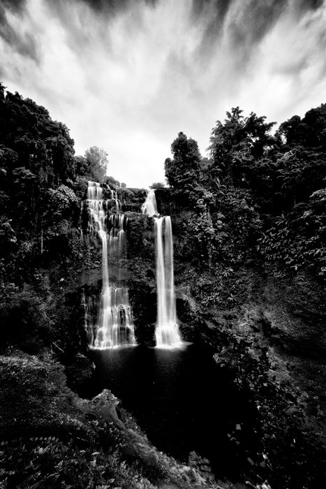   Disparo en blanco y negro de larga exposición de una cascada, vista vertical