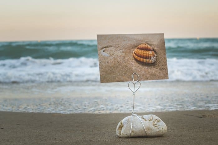 Un soporte para fotos de bricolaje hecho con piedras de playa en la arena, un paisaje marino fabuloso de fondo