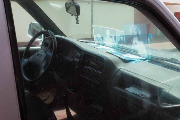 Imágenes reflejadas en el parabrisas de un automóvil estacionado.