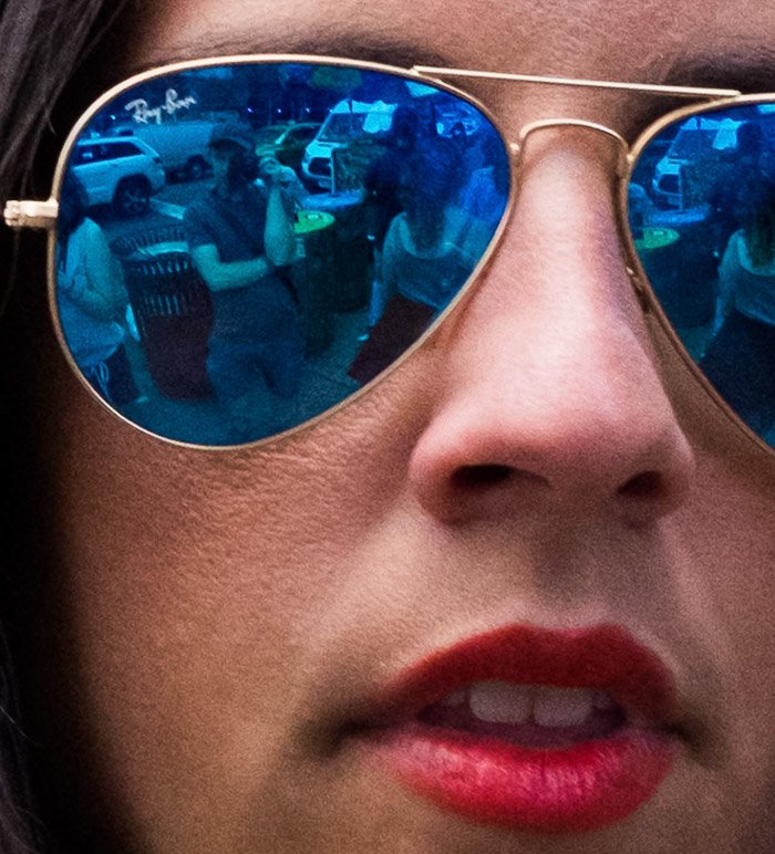 Autorretrato de reflexión en las lentes de una niña vestida de azul Ray Bans polarizados