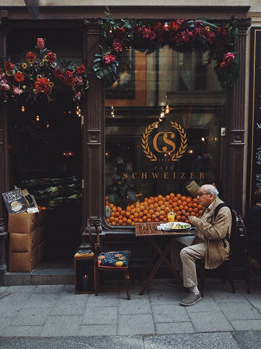Foto de un anciano desayunando en un pequeño café
