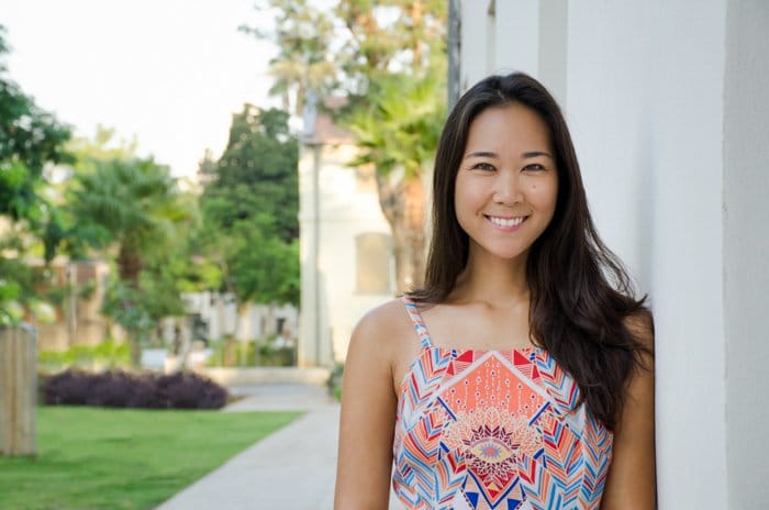 Retrato de una bella mujer asiática sonriendo fuera de una casa blanca - guía para recortar fotos