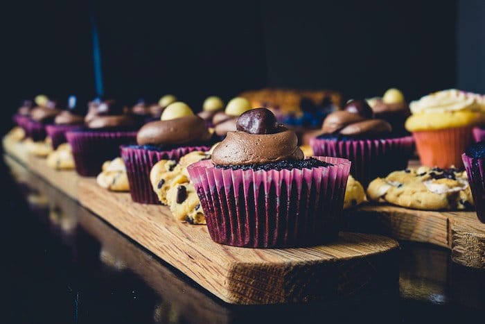 Foto atmosférica de galletas y cupcakes contra un fondo oscuro