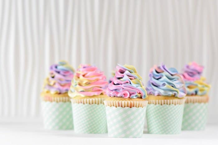 Photoshot luminoso y aireado de cinco cupcakes de colores sobre un fondo claro