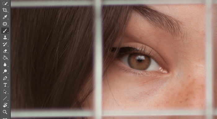 Un primer plano de los ojos de una niña con una valla frente a ella abierta para editar