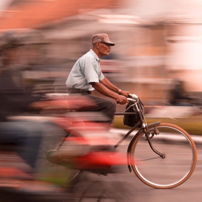 Foto de un hombre mayor en bicicleta con efecto de desenfoque de movimiento