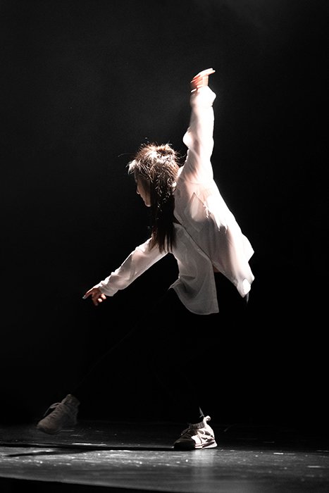 Fotografía de danza atmosférica de una bailarina a mitad de la actuación.
