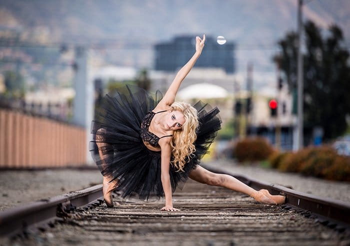 Un retrato de danza atmosférica de una bailarina en las vías del tren