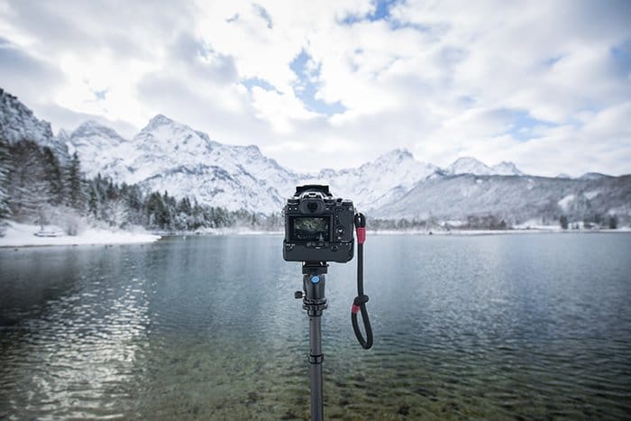 Foto de una cámara en un monopie frente a un lago