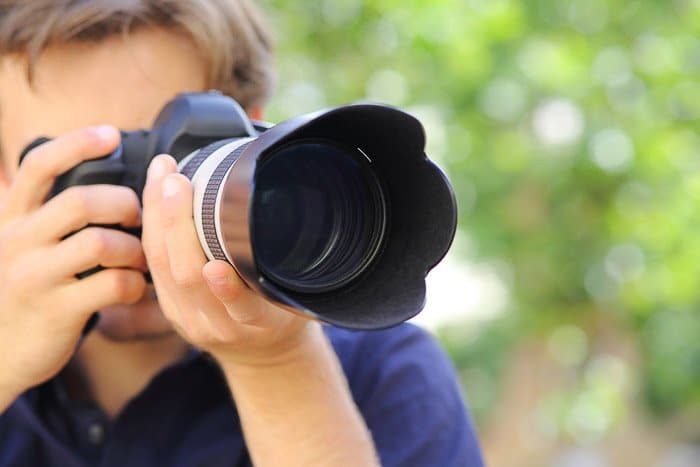 Un fotógrafo que toma una foto con una cámara DSLR: comprensión de las diferentes partes de la cámara
