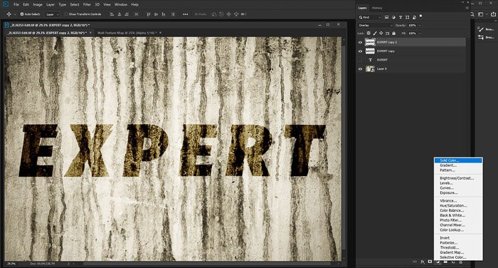 Una captura de pantalla de la edición de una foto de una pared de grunge con textura con la palabra 'experto' usando el mapa de desplazamiento de Photoshop.