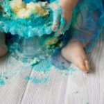 Los pies de un bebé cubiertos con glaseado verde - Cake Smash Photography
