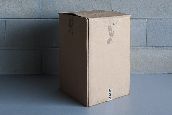 Una caja de cartón al lado de una pared de piedra para hacer una fotografa de caja de luz de bricolaje