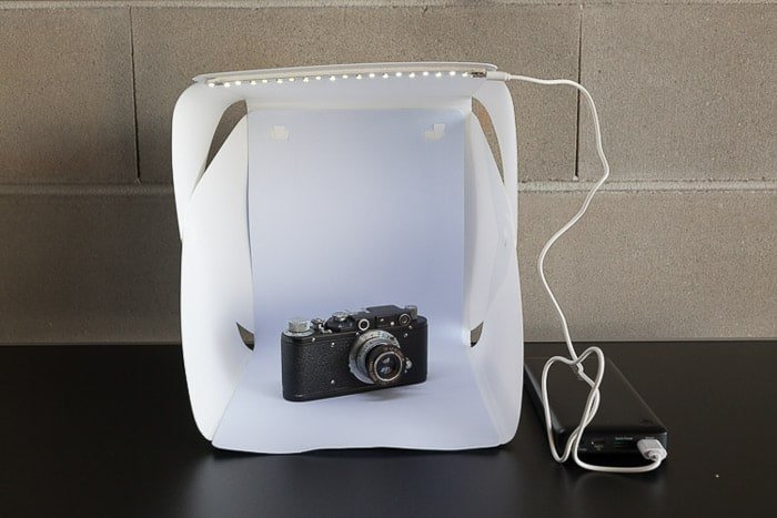 Una configuración de sesión de fotos que contiene una cámara en una caja de luz de bricolaje