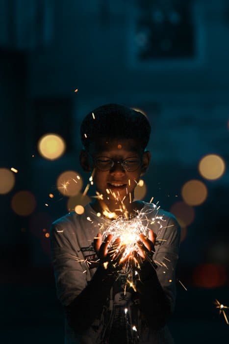 Un retrato de un niño sosteniendo una cadena de luces parpadeantes tomada con un fotomatón de bricolaje