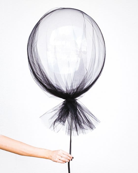 foto surrealista de una mano sosteniendo un globo cubierto de tela