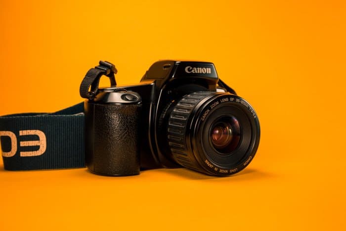 una cámara réflex digital canon sobre una superficie naranja brillante