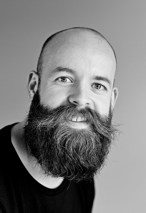 una foto profesional en la cabeza en blanco y negro de un hombre barbudo