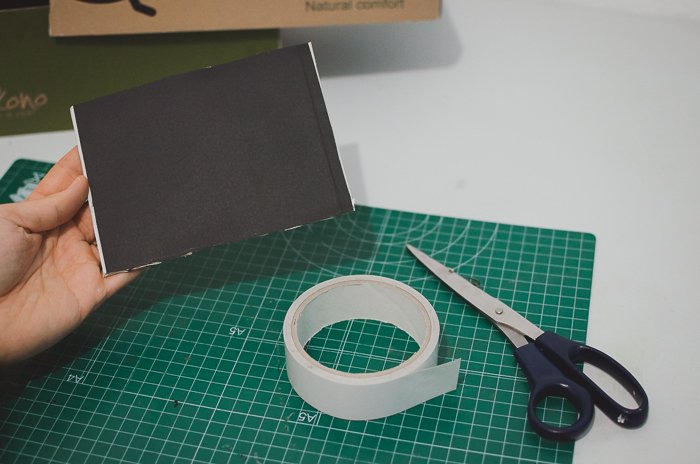 Cortando papel negro y una caja de zapatos para hacer un proyector DIY