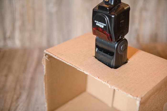 Un flash de cámara insertado en la solapa de una caja de cartón.