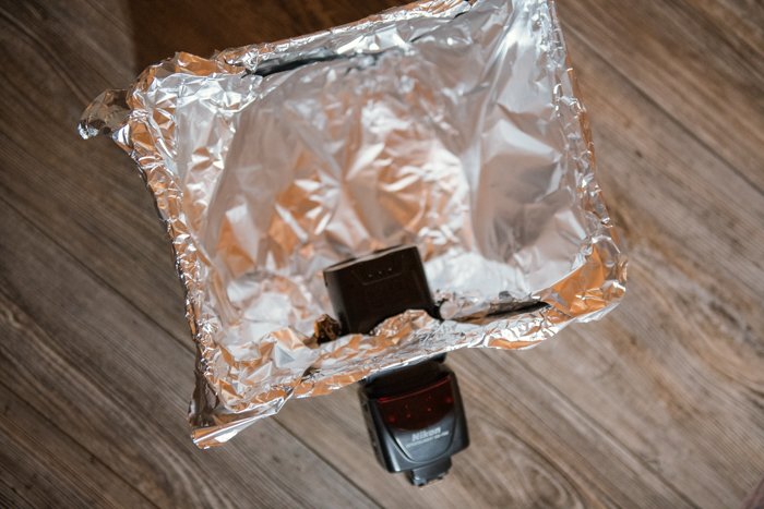 Un flash de cámara insertado en la solapa de una caja de cartón cubierta con papel aluminio.