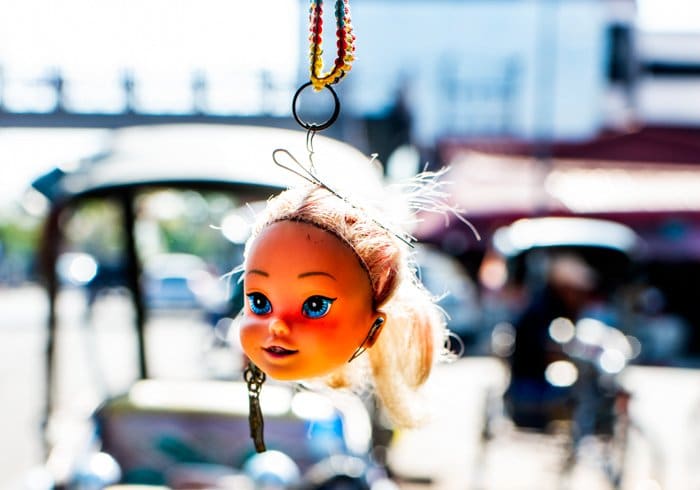 Una cabeza de muñecas colgando de un coche o una bicicleta
