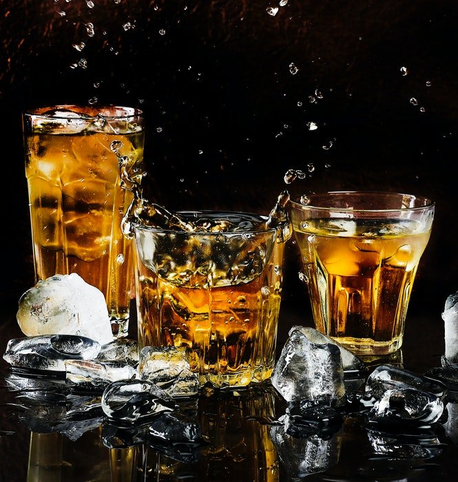 Tres cócteles de whisky rodeados de hielo