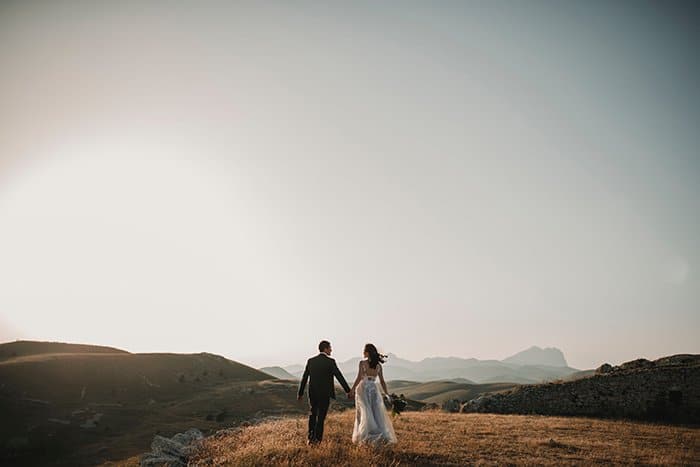 Foto de boda con drones de una pareja en una colina al atardecer