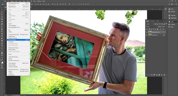 Captura de pantalla de Photoshop editando una imagen de un hombre sosteniendo una pintura enmarcada 
