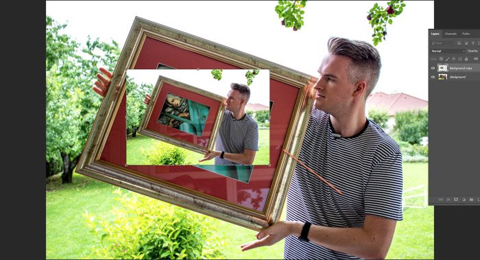 Captura de pantalla de Photoshop editando una foto de un hombre sosteniendo una pintura enmarcada
