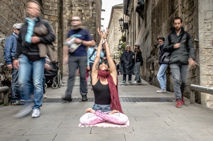 Una chica en una pose de yoga en medio de una calle concurrida: conceptos básicos de DSLR para principiantes en fotografía