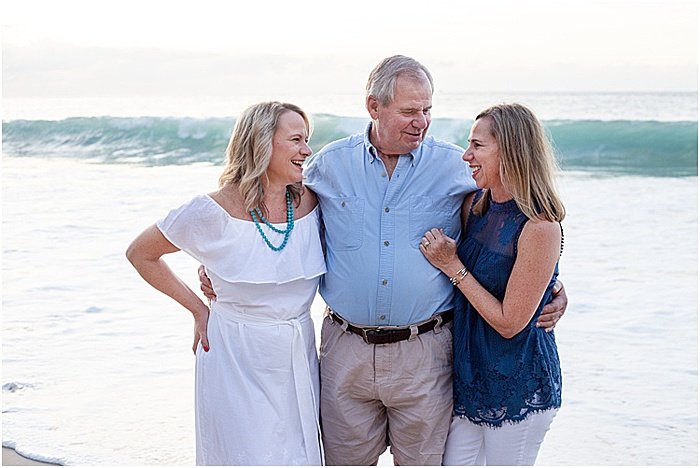 Un dulce retrato de una familia de tres posando en la playa - fotografía emocional