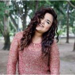 Una modelo femenina sonriente posando al aire libre - fotografía emocional