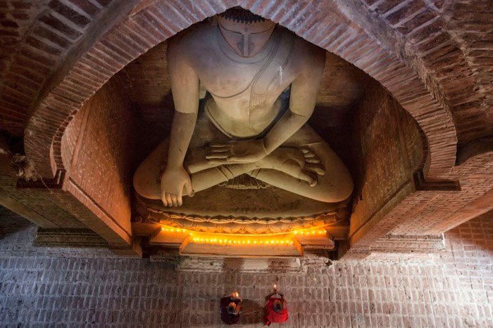 Vista aérea de monjes budistas rezando bajo una estatua de Buda - accesorios de fotografía de viajes