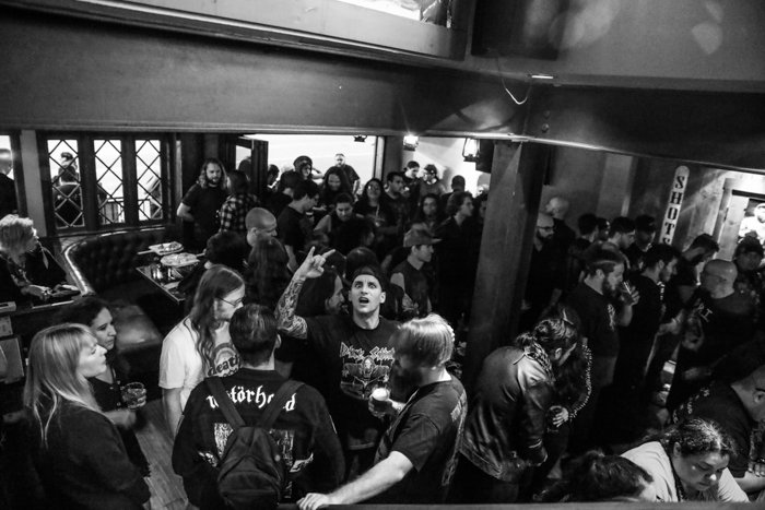 Fotografía de un evento en blanco y negro de una multitud en el interior de un bar o sala de conciertos