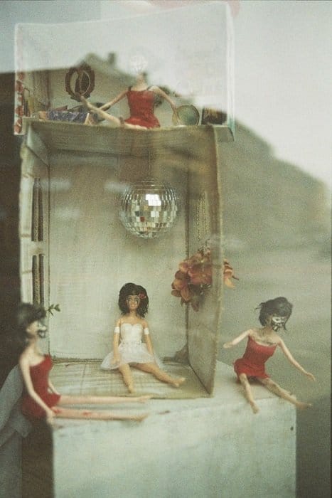 fotografía de una pequeña casa de muñecas tomada con película caducada, con un tono gris y grano de película