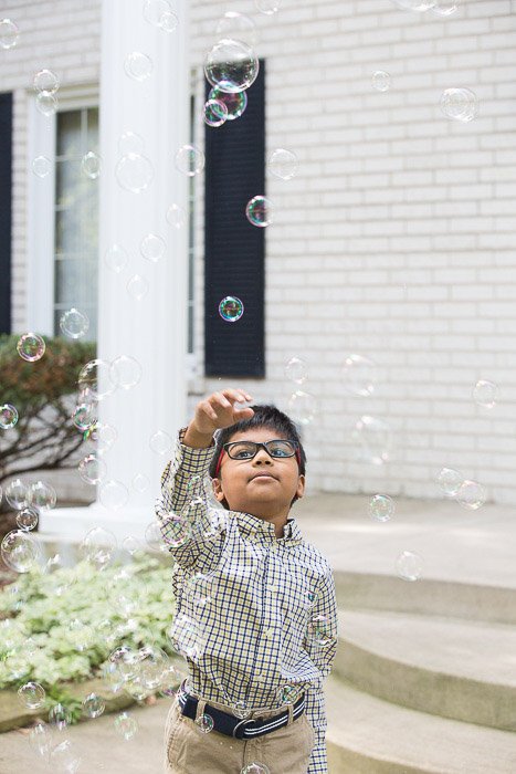 Retrato al aire libre de un niño jugando con burbujas