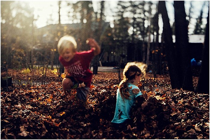 Foto de niños jugando con hojas de otoño.