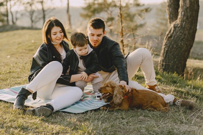 Retrato familiar haciendo un picnic con su perro