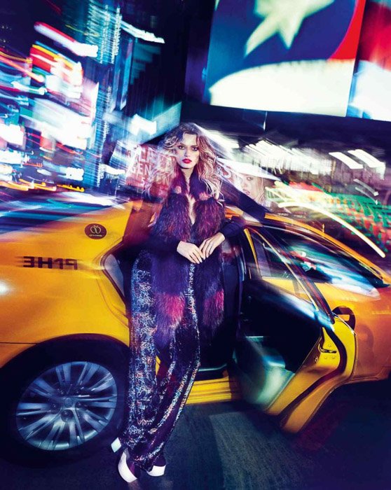 Sorprendente potrrait de una modelo de moda femenina posando junto a un taxi - fotografía de moda al aire libre por la noche