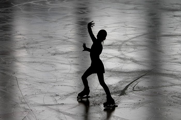Hermosa fotografía de patinaje artístico de la silueta de una patinadora sobre el hielo