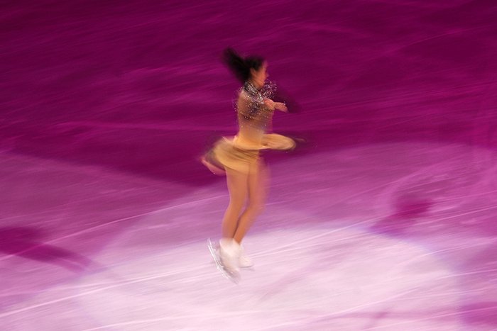 Fotografía borrosa de patinaje artístico de una patinadora girando sobre el hielo