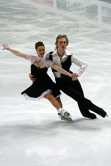 Hermosa fotografía de patinaje artístico de una pareja bailando sobre el hielo