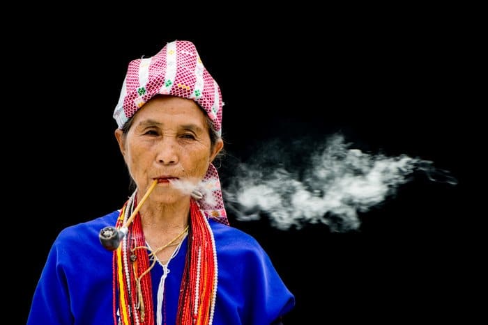 Una mujer Karen fumando una pipa contra un fondo negro - composición de fotografía de figura a tierra