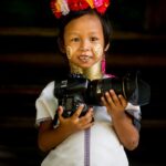 Una joven karen sosteniendo una gran cámara réflex digital